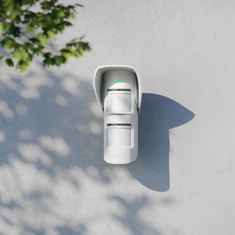 Ajax MotionProtect outdoor sensor with hood mounted on wall, providing weather protection and reliable motion detection