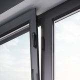 Ajax wireless black DoorProtect opening detector installed on window frame for advanced home and office security monitoring.