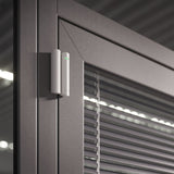 Ajax wireless DoorProtect opening detector in white, mounted on a door frame for reliable smart home security.