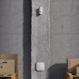 Lifestyle Image of device installed on a concrete wall in a warehouse setting.